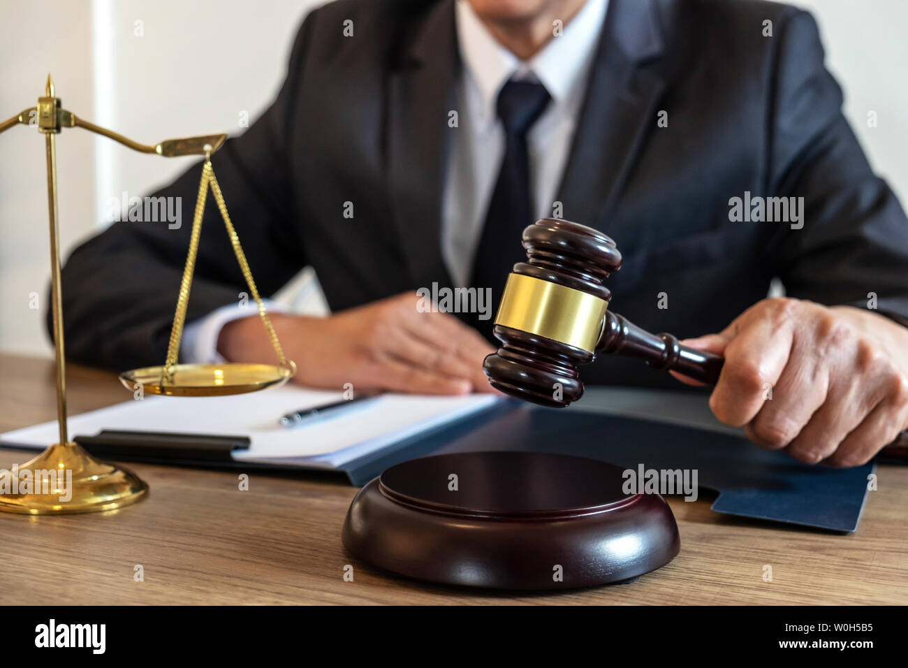 Legal law, advice and justice concept, counselor lawyer or notary working on a documents and report of the important case and wooden gavel, brass scal Stock Photo