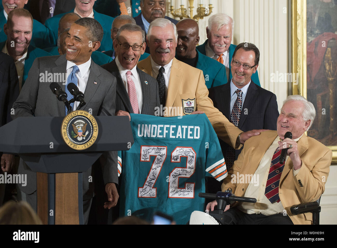 President Barack Obama (L) receives a commemorative jersey from hall of  fame coach Don Shula (R) as Obama honors Super Bowl VII Champion Miami  Dolphins and their perfect season, during a ceremony