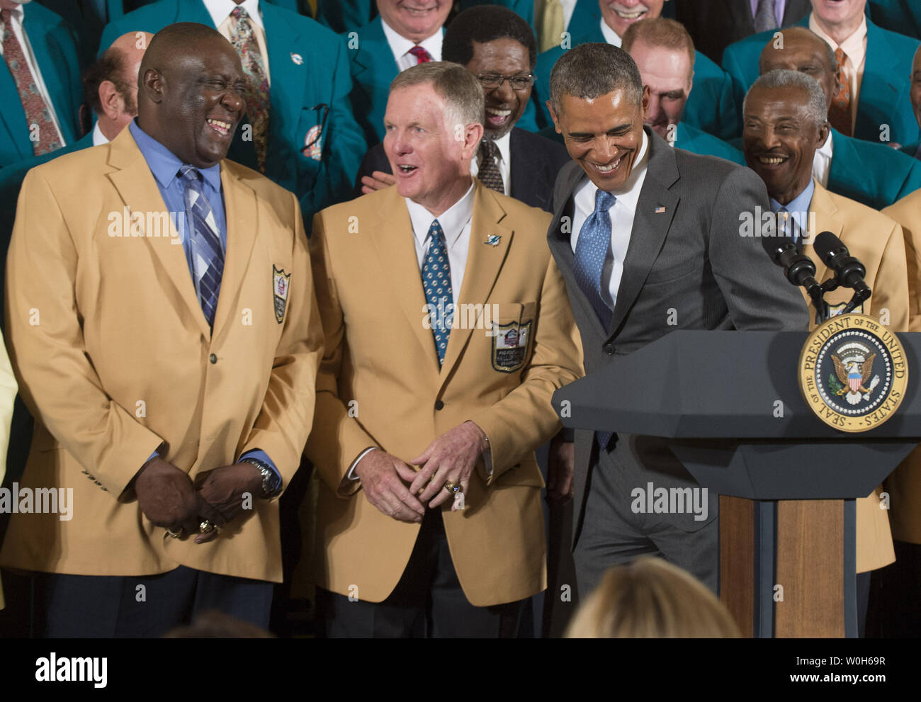 President Barack Obama jokes with members of the 1972 Miami Dolphins,  including offensive guard Larry Little (L), and quarterback Bob Griese,  during a ceremony honoring the Super Bowl VII Champions and their