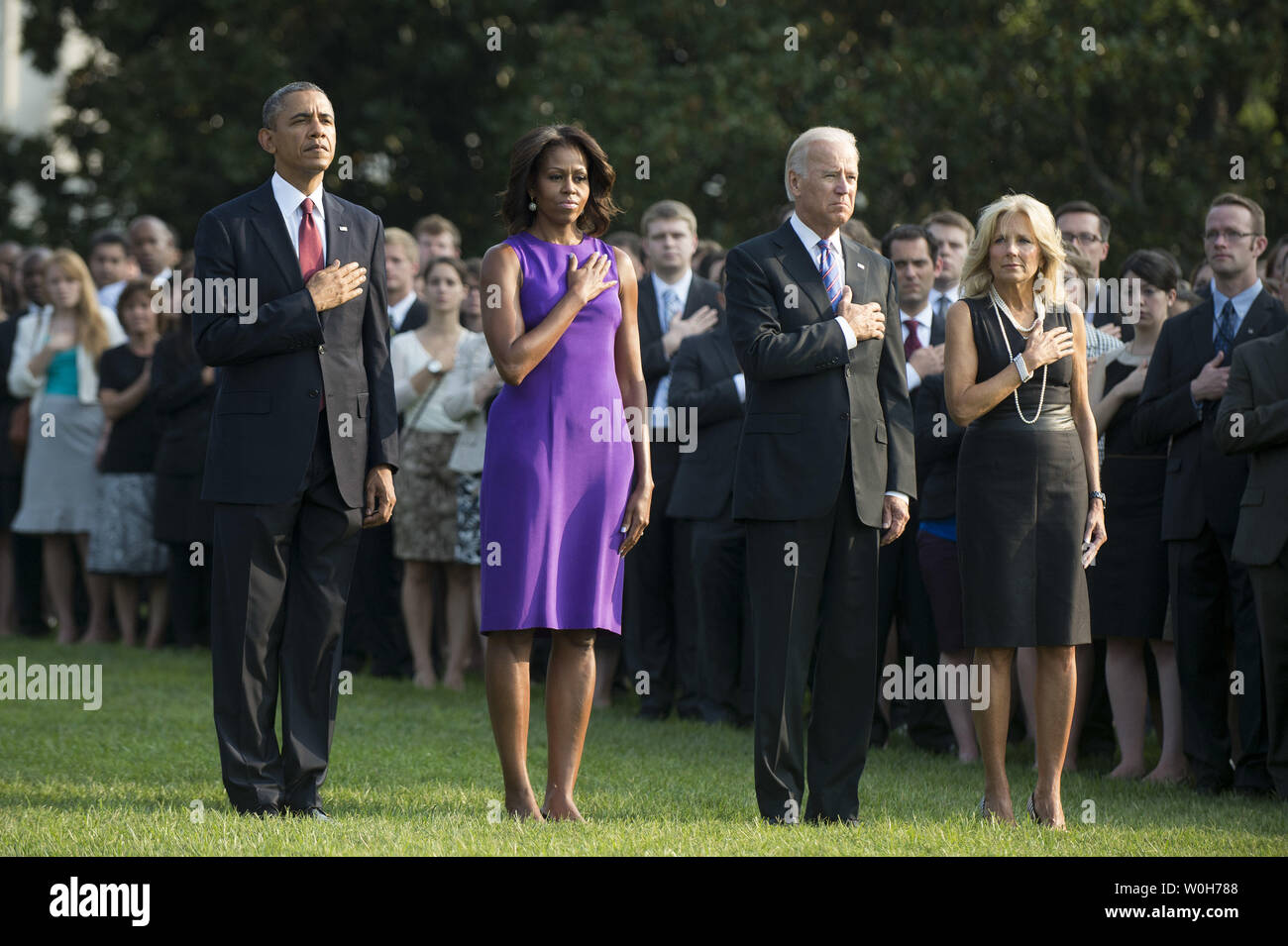 President Barack Obama (L), First Lady Michelle Obama, Vice President Joe Biden, Dr. Jill Biden and White House staff observe a moment of silence for the 12 anniversary of the 9/11 terrorist attacks, at the White House on September 11, 2013 in Washington, D.C. UPI/Kevin Dietsch Stock Photo