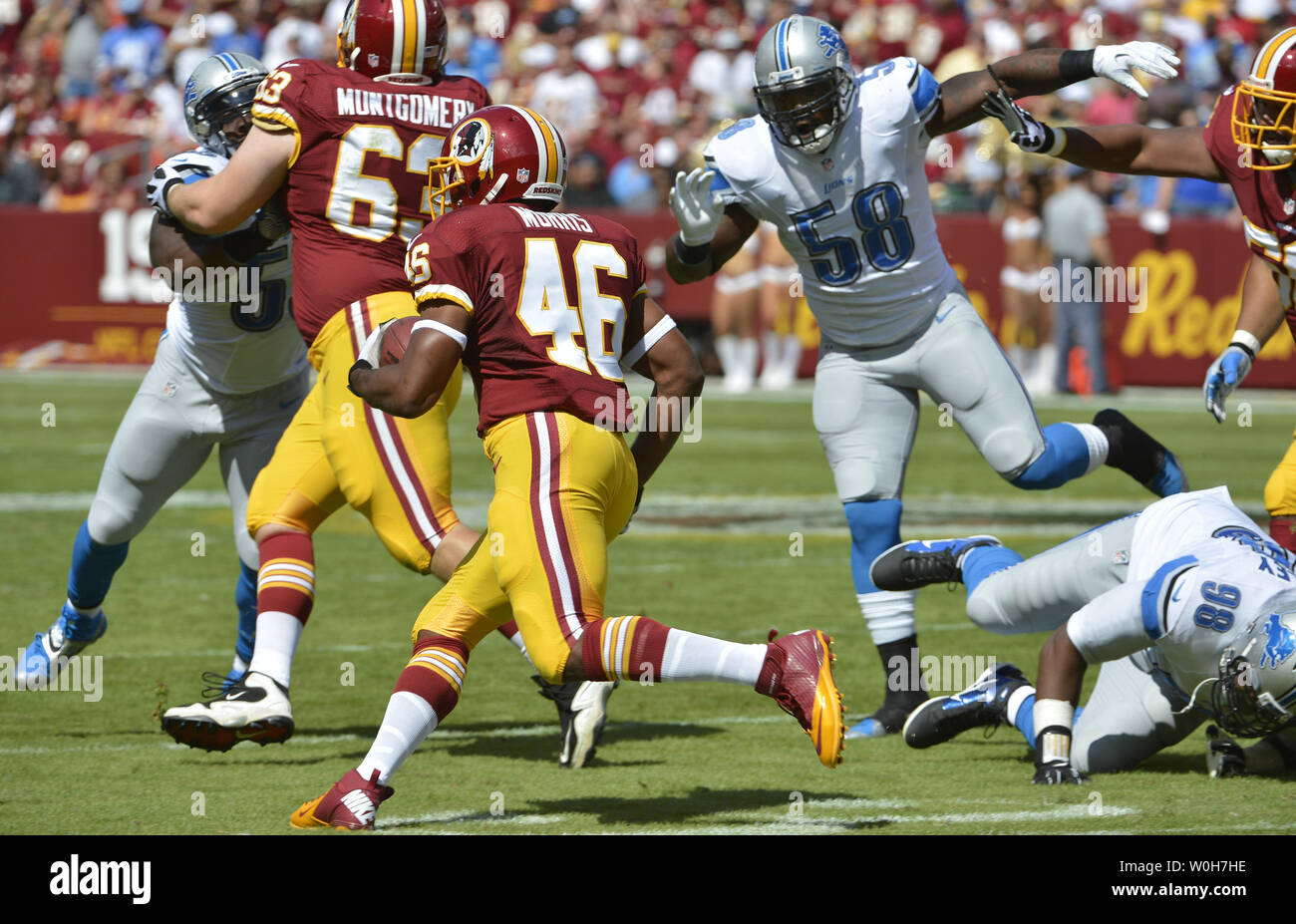 Washington Redskins running back Alfred Morris (C) looks for running room as he follows offensive lineman Will Montgomery as Detroit Lions linebacker Ashlee Palmer pursues, during 1st quarter at FedEx Field, Landover Maryland, September 22, 2013. The Lions won, 27-20, and the Redskins fell to 0-3 to open the season.  UPI/Mike Theiler Stock Photo