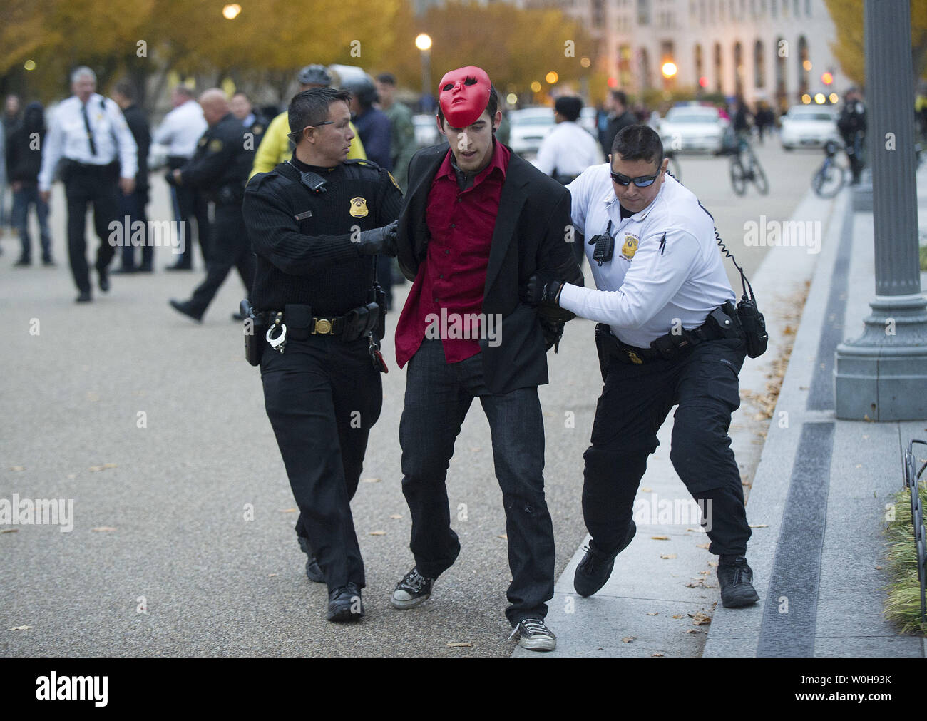 A demonstrator is arrested by Secret Service Uniformed Police during a small protest outside of the White House in Washington, D.C. on November 5, 2013. Protesters gathered in Washington, D.C. and around the world as part of the Million Mask March to protest against government corruption and corporate greed. UPI/Kevin Dietsch Stock Photo