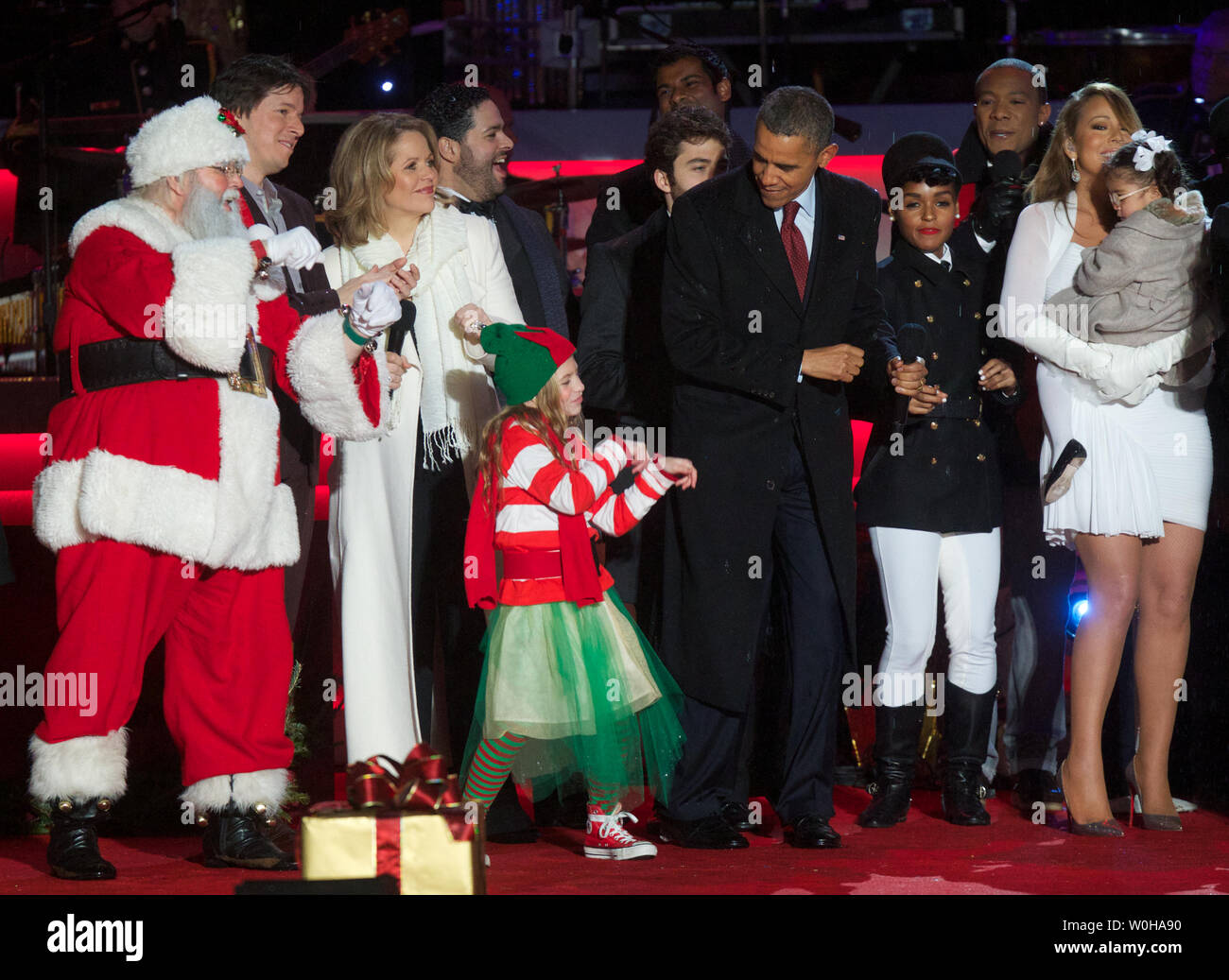 President Barack Obama dances with an elf entertainer next to Janelle Monae (2nd Right),  Mariah Carey (Right), Renee Fleming (3rd Left) and other guests after taking part in the 2013 National Christmas Tree Lighting on the Ellipse in Washington, D.C. December 6, 2013.   UPI/Molly Riley Stock Photo