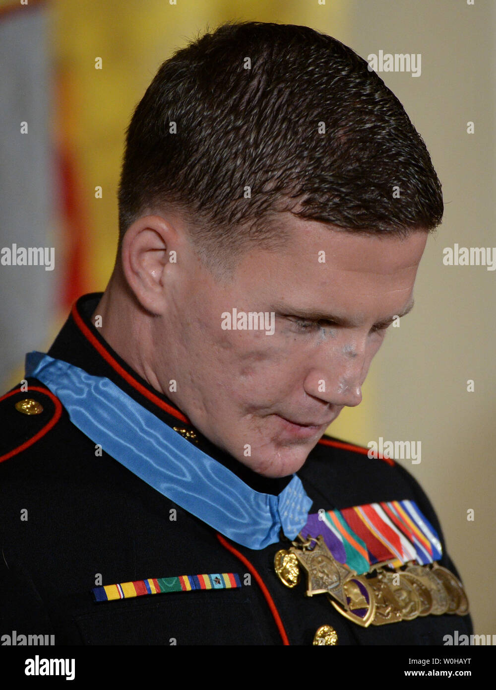 Retired Marine William 'Kyle' Carpenter bows his head during the benediction in a ceremony where President Barack Obama awarded him the  Medal of Honor in the East Room of the White House in Washington, DC on June 19, 2014.  Carpenter, 24, of Gilbert, South Carolina was awarded the nation's highest award for gallantry for covering a grenade with his body to save a Marine's life in Afghanistan in 2010.    UPI/Pat Benic Stock Photo