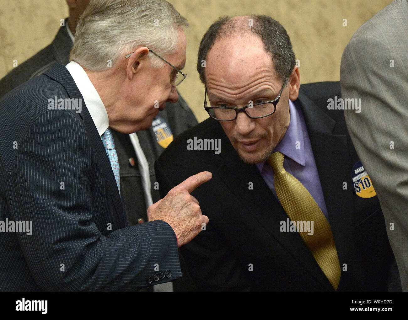 Senate Majority Leader Harry Reid, D-Nev,. talks to Labor Secretary Thomas Perez during a press conference on raising the minimum wage to $10.10 per hour, on Capitol Hill in Washington, D.C. on April 3, 2014. UPI/Kevin Dietsch Stock Photo