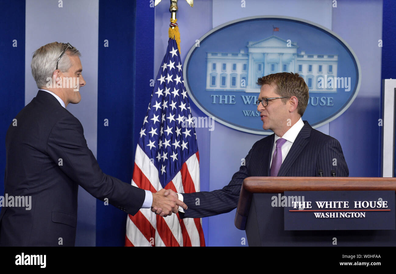White House Press Secretary Jay Carney (R) shakes hands with Chief of