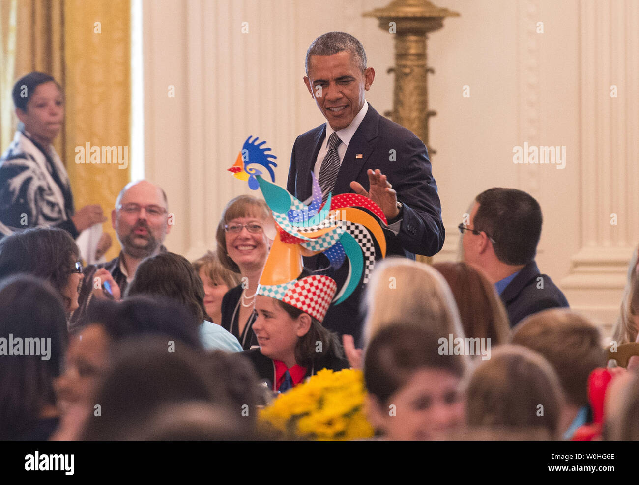 President Barack Obama looks at a child's hat as he arrives at the Kids' State Dinner in the East Room at the White House on July 18, 2014 in Washington, D.C. UPI/Kevin Dietsch Stock Photo