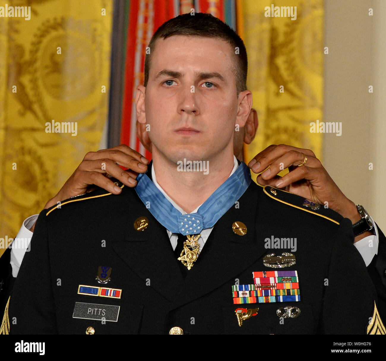 U.S. President Barack Obama presents the Medal of Honor to former Army Staff Sergeant Ryan Pitts during a ceremony in the East Room of the White House on July 21, 2014.  Pitts, from the 2nd Platoon, Chosen Company, 2nd Battalion (Airborne), 503rd Infantry Regiment, 173rd Airborne Brigade, was awarded the Nation's highest military honor for his courageous actions during combat operations at Vehicle Patrol Base Kahler in Kunar Province, Afghanistan on July 13, 2008.       UPI/Pat Benic Stock Photo