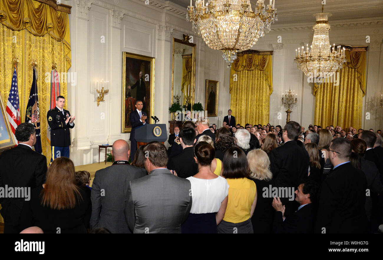 U.S. President Barack Obama and former Army Staff Sergeant Ryan Pitts (L) applaud the families of unit members of Pitts who lost their lives during a Medal of Honor ceremony for Pitts iin the East Room of the White House on July 21, 2014.  Pitts, from the 2nd Platoon, Chosen Company, 2nd Battalion (Airborne), 503rd Infantry Regiment, 173rd Airborne Brigade, was awarded the Nation's highest military honor for his courageous actions during combat operations at Vehicle Patrol Base Kahler in Kunar Province, Afghanistan on July 13, 2008.       UPI/Pat Benic Stock Photo