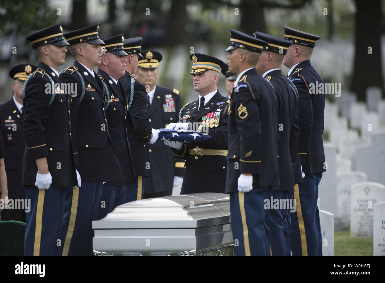 An Army Honor Guard prepares a flag to be presented to Susan Myers, the widow of Army Maj. Gen. Harold J. Greene, during Greene's graveside service at Arlington National Cemetery on August 14, 2014 in Arlington, Virginia. Greene was shot and killed by a uniformed Afghan soldier while Greene was visiting a military academy in Kabul. UPI/Kevin Dietsch Stock Photo