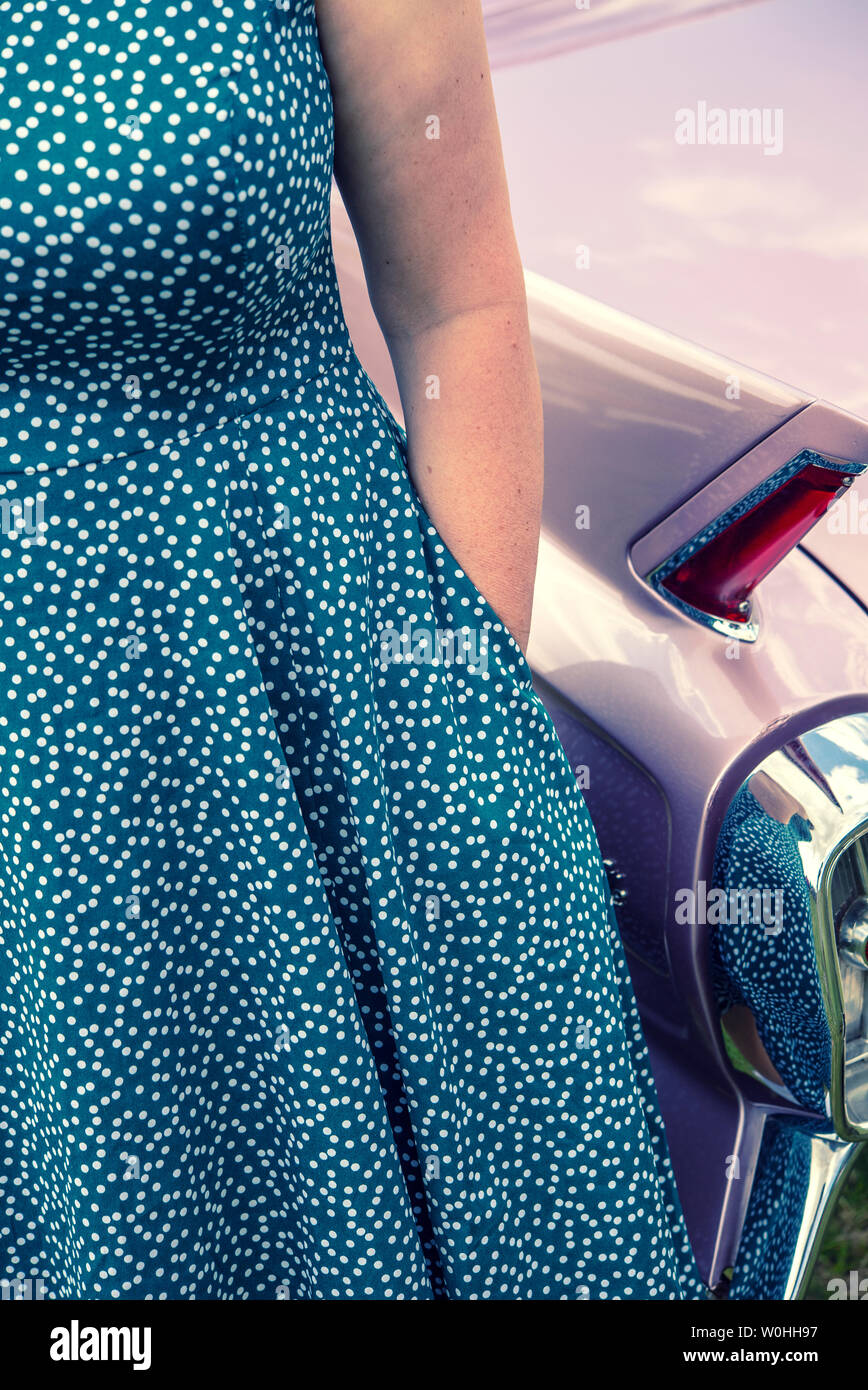 Woman in a 1950s style dress standing in front of a vintage American  Cadillac Stock Photo - Alamy