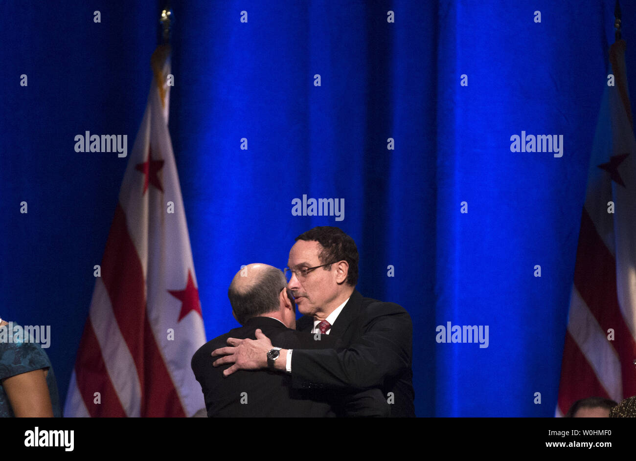Outgoing Washington, D.C. Mayor Vincent Gray hugs D.C. Council Chair Phil Mendelson during the Inauguration for newly elected mayor Murial Bowser in Washington, D.C. on January 2, 2015. The three-term councilwoman defeated incumbent Vincent Grey to become the District's 7th Mayor. Kevin Dietsch/UPI Stock Photo