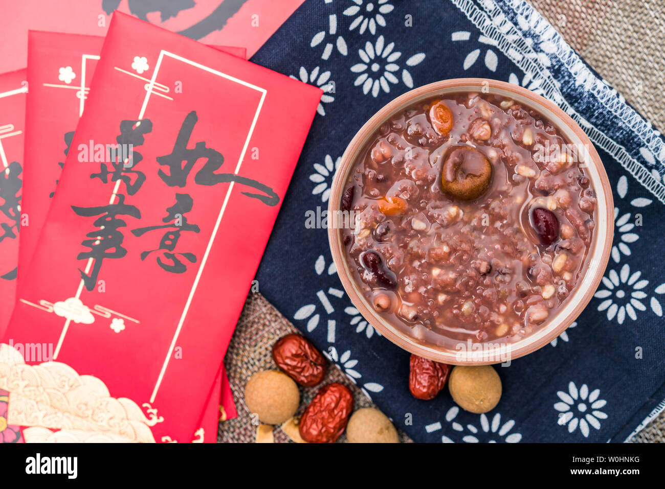 Laba porridge under the background of couplets and red envelopes Stock Photo