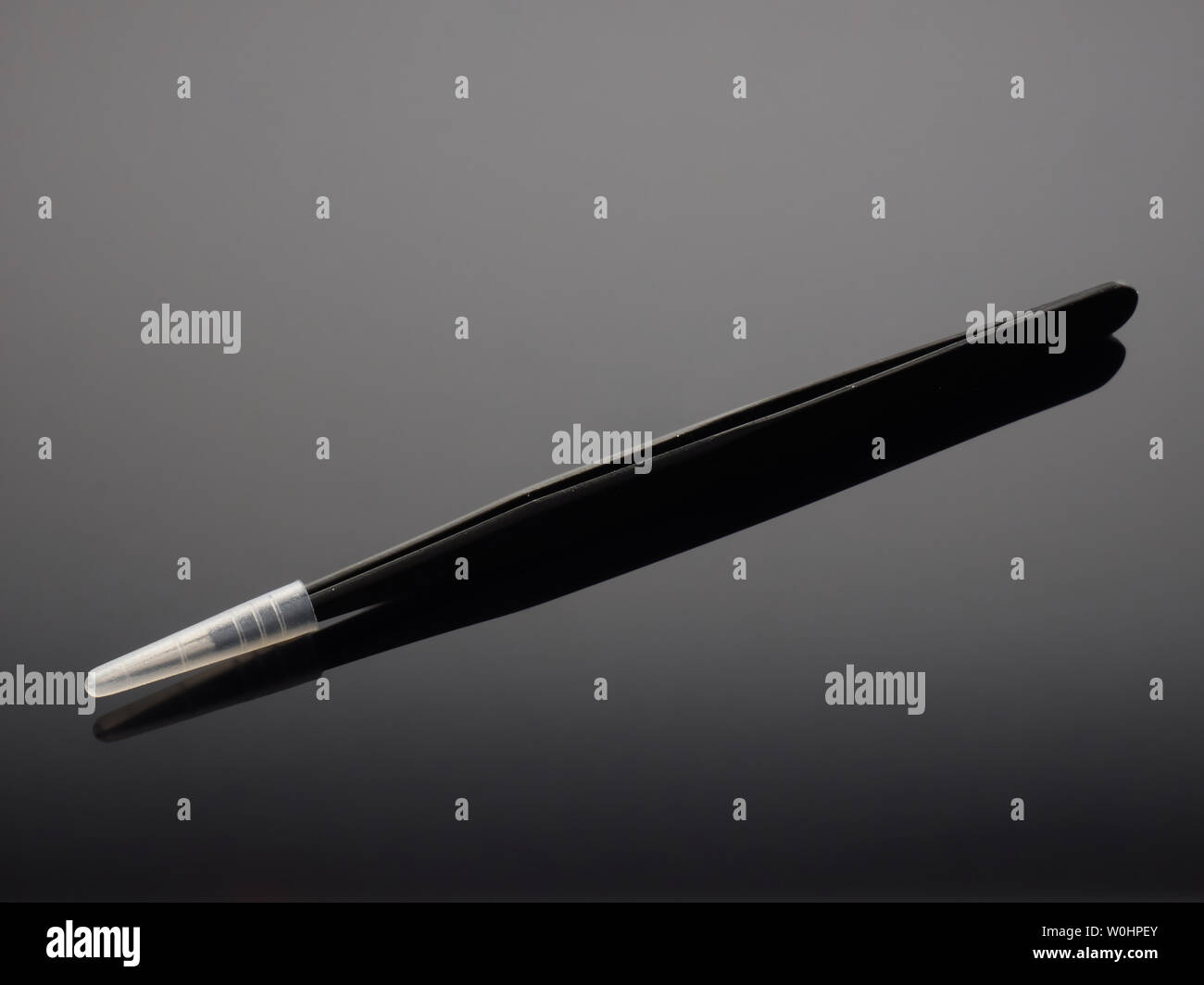 Dental tweezers on gray background with gradient Stock Photo - Alamy
