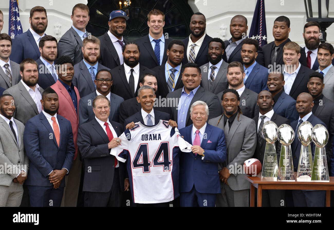U.S. President Barack Obama (C) is flanked by Team Owner Robert Kraft (R)  and Head Coach Bill Belichick as he holds a souvenir jersey and poses with  the NFL Suoer Bowl Champion