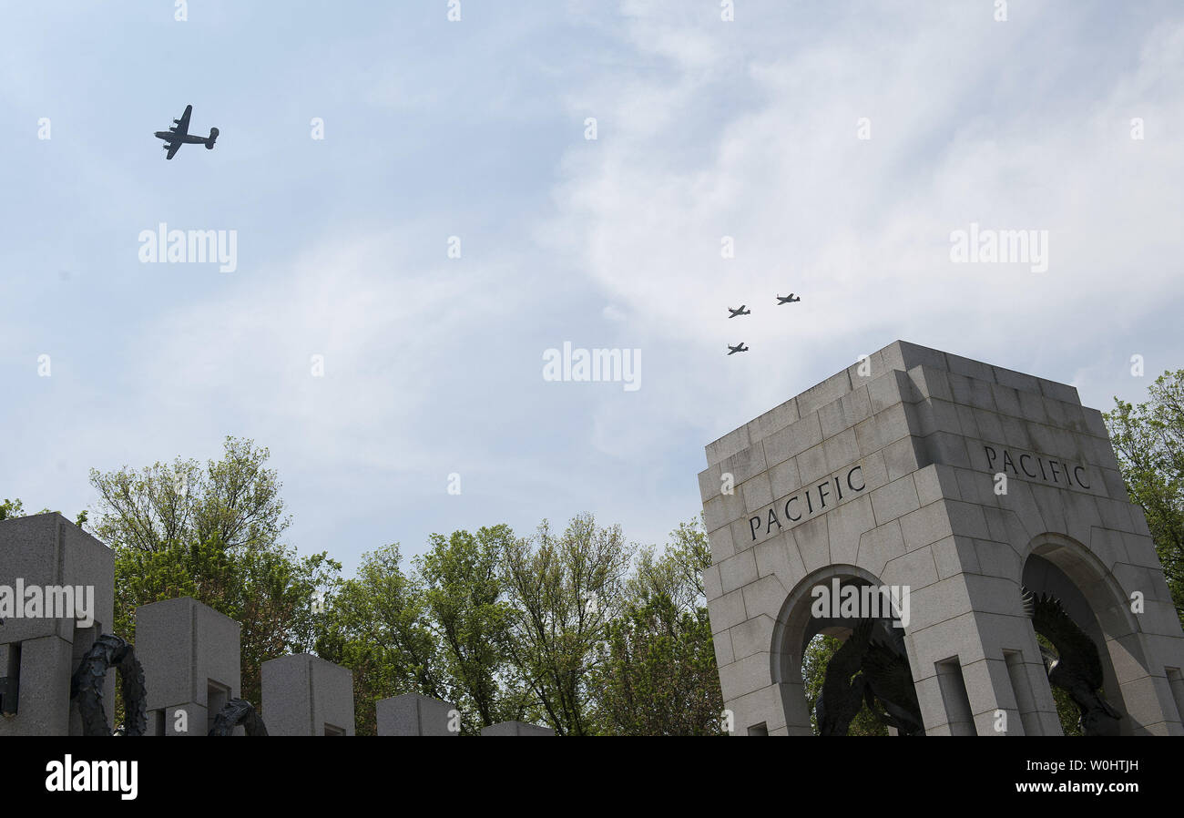 World War II era aircraft flies over the National World War II Memorial ...