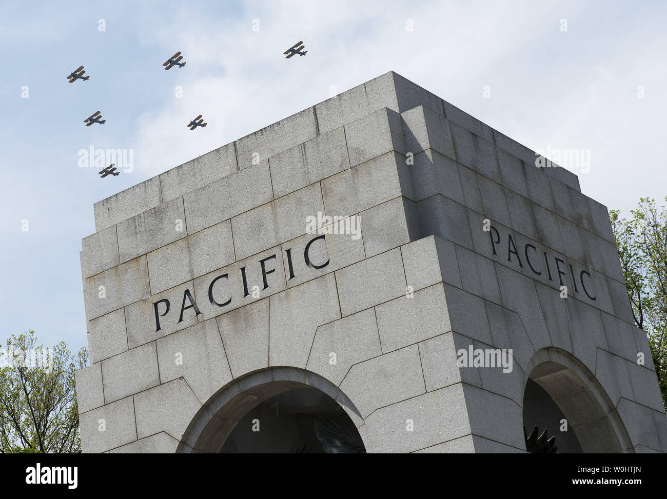 World War II era aircraft flies over the National World War II Memorial ...