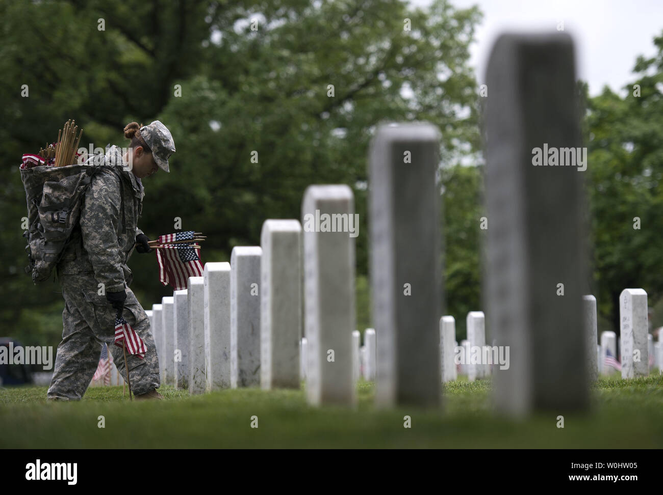 Army Staff Sgt. Robin Reed places a flag at a grave in Arlington National Cemetery during the Flags-In ceremony, in Arlington, Virginia on May 21, 2015. Members of the 3rd U.S. Infantry Regiment (The Old Guard) placed an American flag all of the over 228,000 headstones at Arlington in honor of Memorial Day. Photo by Kevin Dietsch/UPI Stock Photo