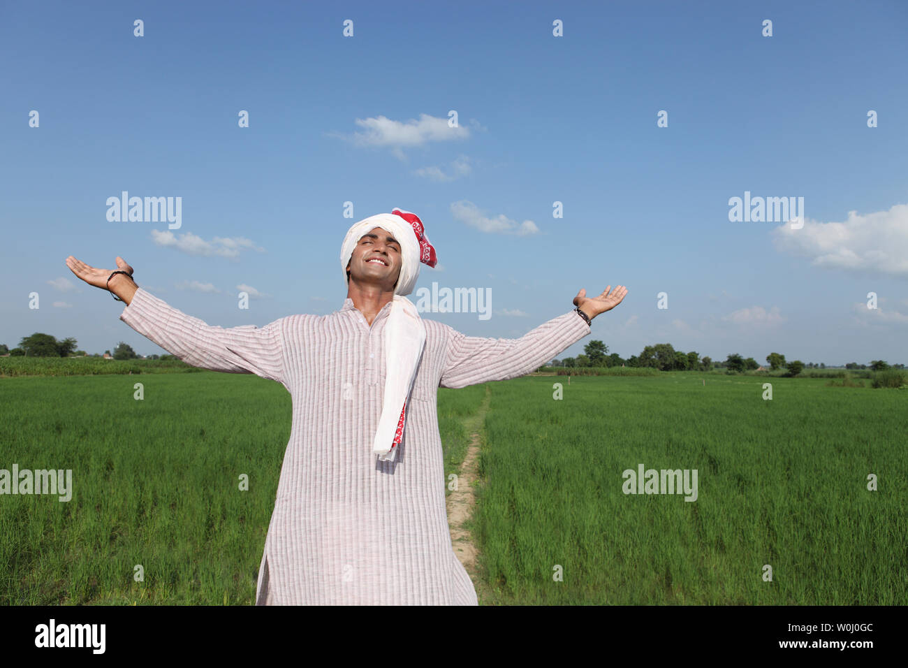 Indian farmer standing in a field Stock Photo - Alamy