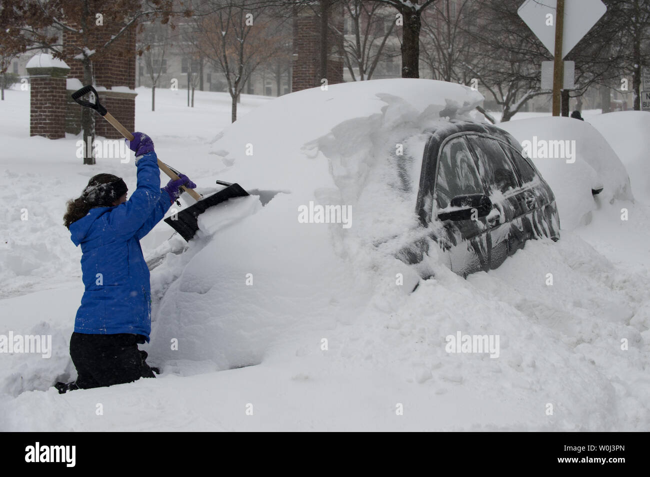 Resident scrapes snow off her car in Northwest Washington, DC during a break in the blizzard that will drop more than 20 inches of snow on the Nation's Capital on January 23, 2016. The massive blizzard has brought most of the East Coast to a standstill with high winds and more than 30 inches of snow predicted in some areas.   Photo by Pat Benic/UPI Stock Photo