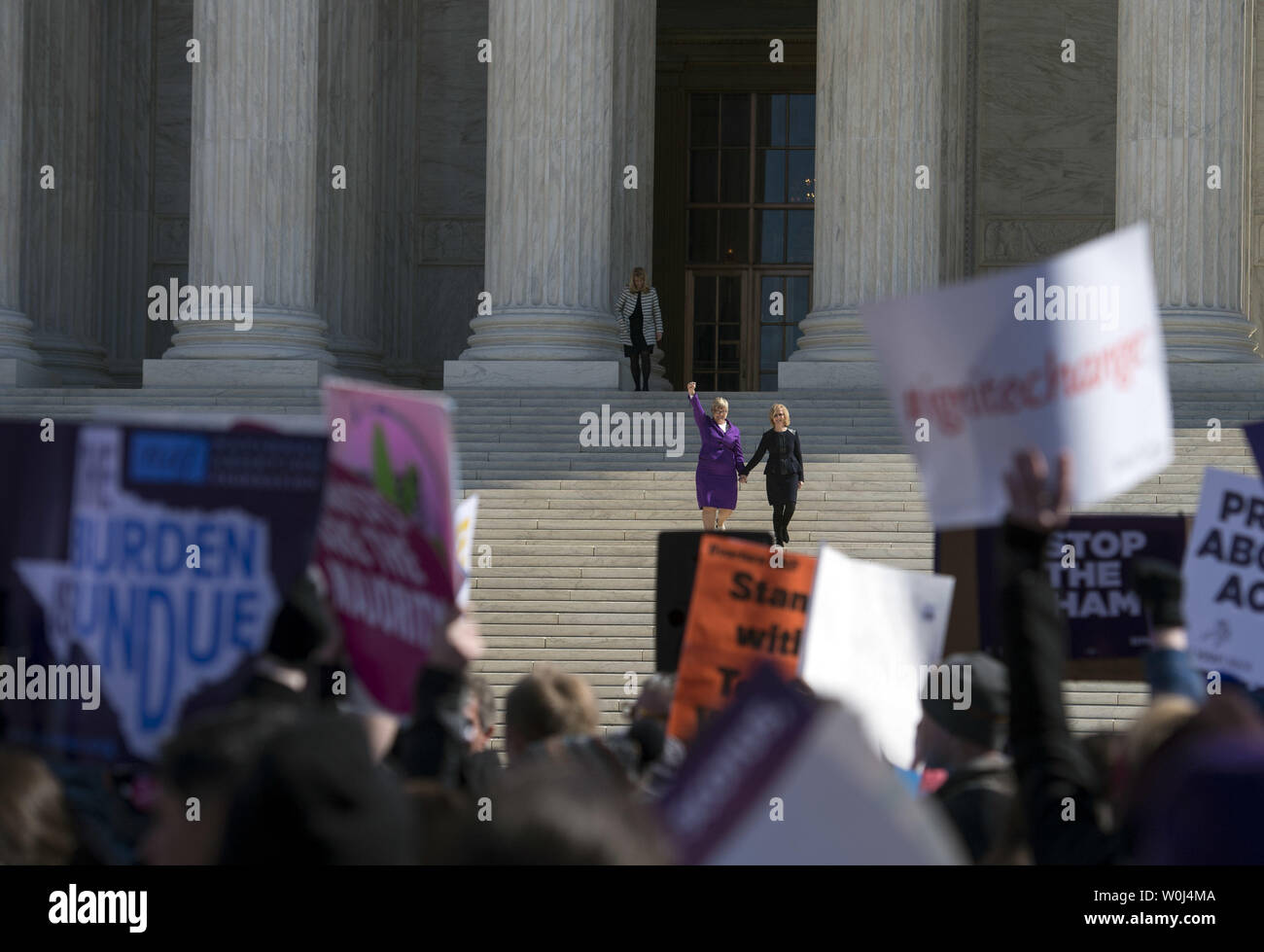 Lead plaintiff Amy Hagstrom Miller (L), CEO of Whole Woman's Health, and Nancy Northup, CEO of Center for Reproductive Rights, are seen through protestors signs as they walk down the steps of the Supreme Court after the Court heard arguments in the Whole Woman’s Health v. Hellerstedt case, at the Supreme Court in Washington, D.C. on March 2, 2016. The case The case will decide the legality of a 2013 Texas law that plaintiffs say restricts a woman's constitutional right to end a pregnancy by putting an 'undue burden' on them. Photo by Kevin Dietsch/UPI Stock Photo