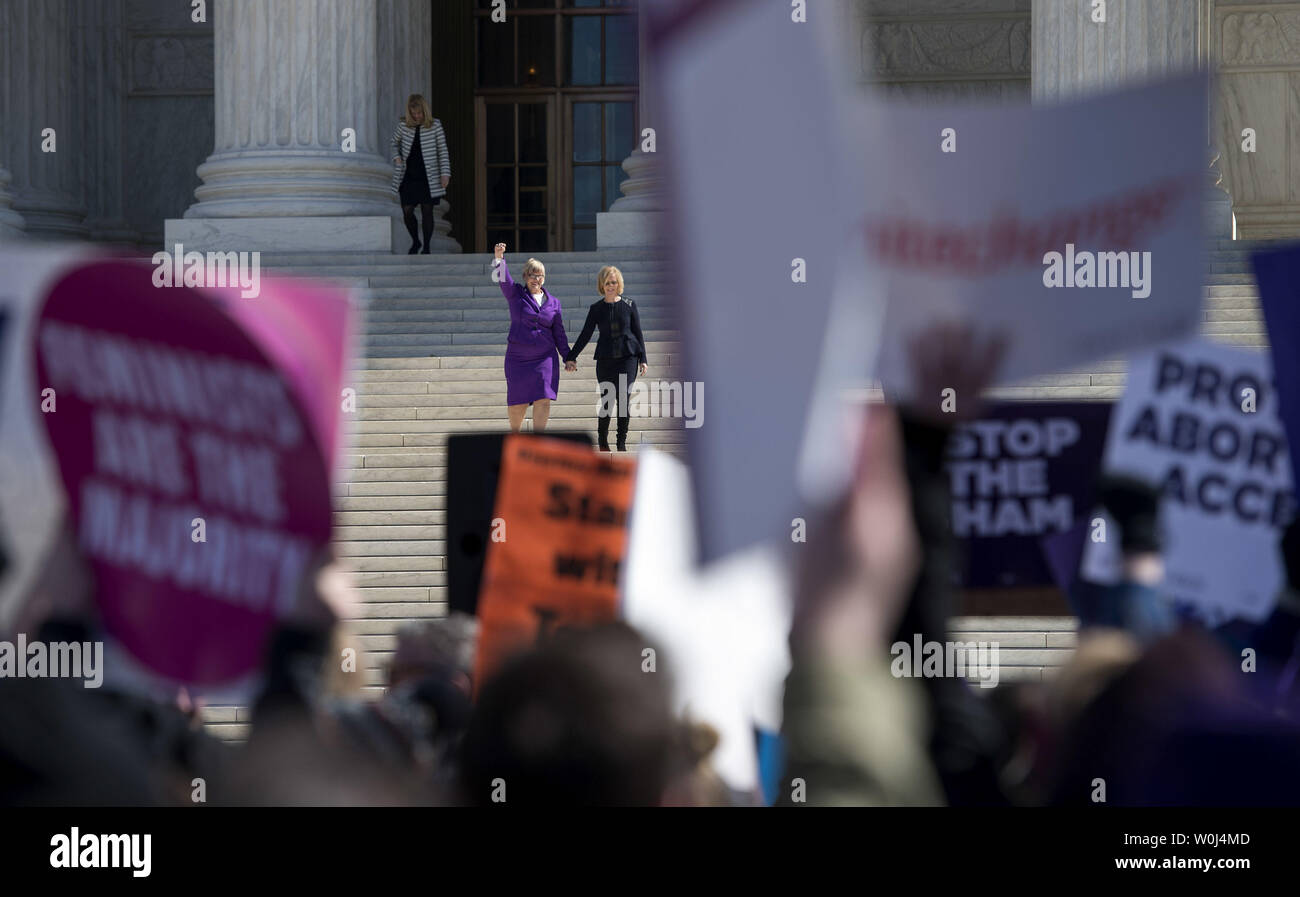 Lead plaintiff Amy Hagstrom Miller (L), CEO of Whole Woman's Health, and Nancy Northup, CEO of Center for Reproductive Rights, are seen through protestors signs as they walk down the steps of the Supreme Court after the Court heard arguments in the Whole Woman’s Health v. Hellerstedt case, at the Supreme Court in Washington, D.C. on March 2, 2016. The case The case will decide the legality of a 2013 Texas law that plaintiffs say restricts a woman's constitutional right to end a pregnancy by putting an 'undue burden' on them. Photo by Kevin Dietsch/UPI Stock Photo