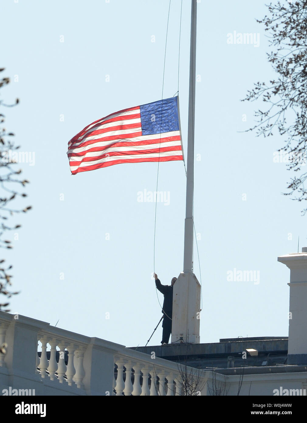 The American flag atop the White House is lowered to halfstaff by