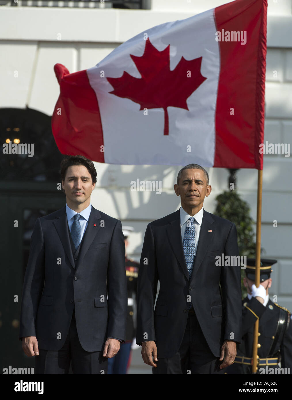 The Canadian flag waves as U.S. President Barack Obama and  Canadian Prime Minister Justin Trudeau (L) listen to the Canadian National Anthem during official welcoming ceremonies for the State Visit of the Canadian PM on the South Lawn of the White House in Washington, DC on March 10, 2016.       Photo by Pat Benic/UPI Stock Photo