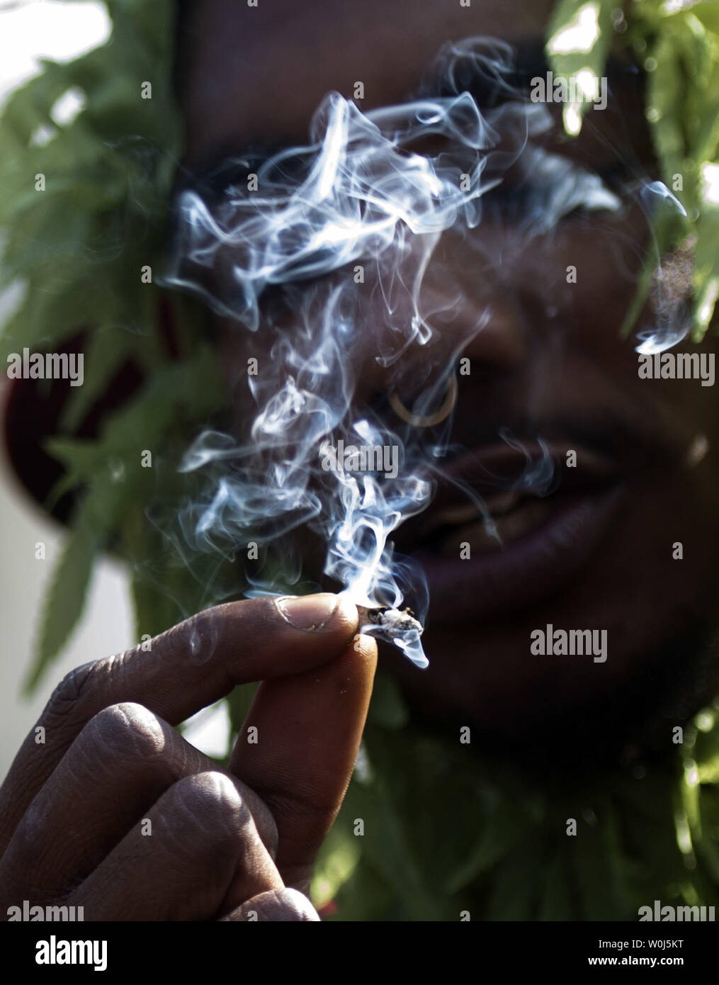A pro-legalization marijuana supporter smokes in front of the White House  with other supporters at 4:20 p.m. during a protest to urge President  Barack Obama to stop marijuana arrest, pardon offenders and, image size:1015x1390