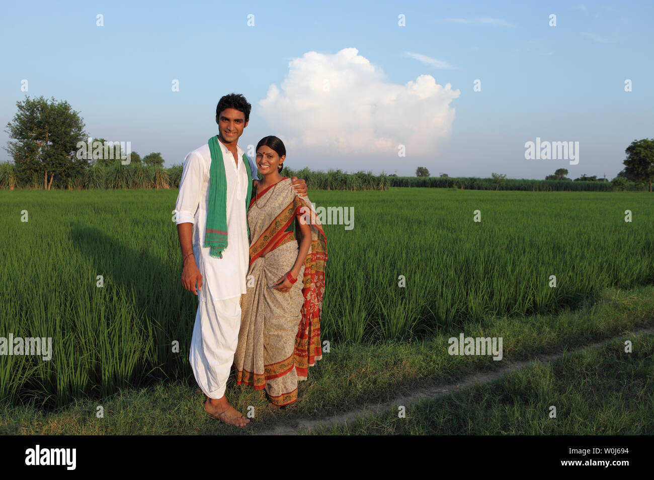 Farmer standing in a field with his wife Stock Photo - Alamy