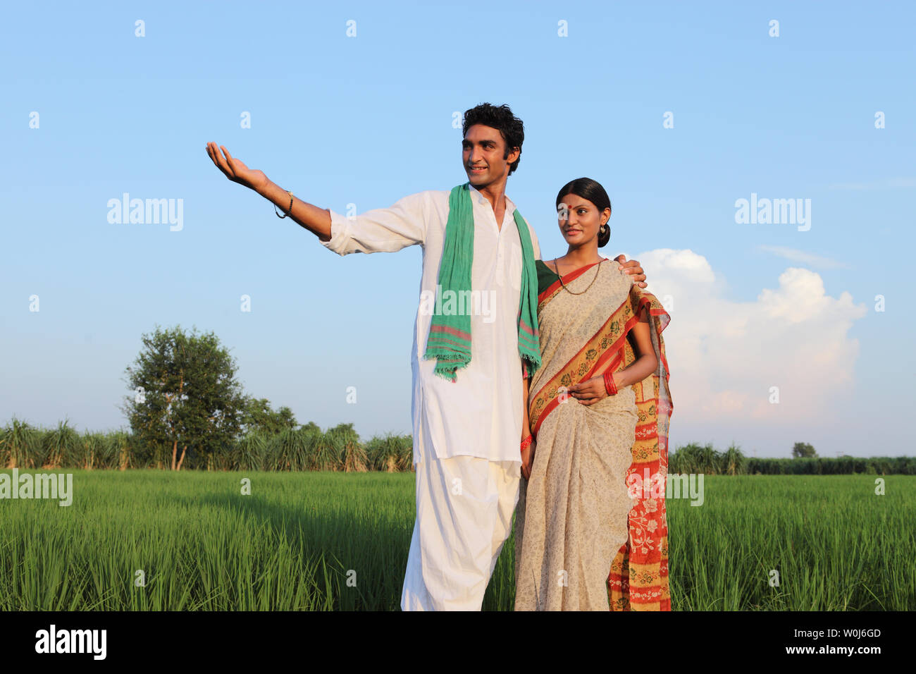 Farmer standing in a field with his wife Stock Photo - Alamy