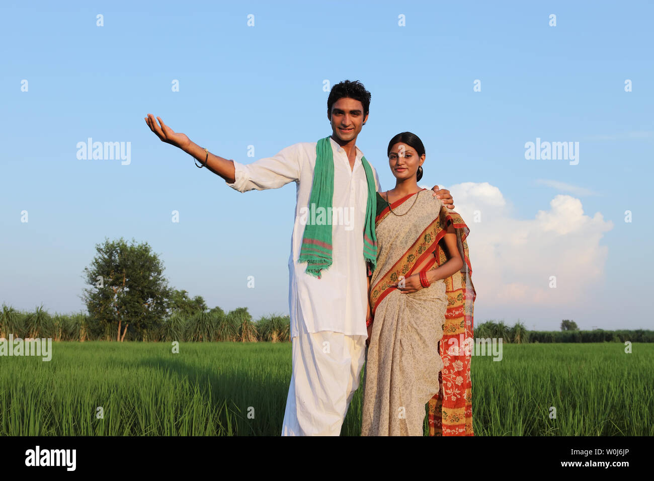 Indian farmer showing field to his wife Stock Photo - Alamy