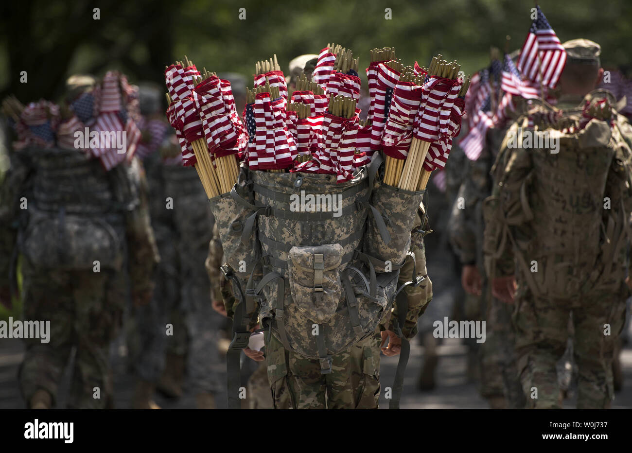 A soldier with the U.S. Army 3rd Infantry Regiment (Old Guard) carries flags as he prepares to place American flag at grave markers as part of the annual Flags-In event for Memorial Day at Arlington National Cemetery in Arlington, Virginia on May 26, 2016. Members of The Old Guard placed an America flag at more than 230,000 grave markers at Arlington in honor of of Nation's fallen military members. The tradition has been conducted since 1948. Photo by Kevin Dietsch/UPI Stock Photo