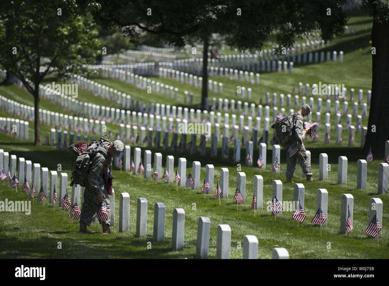 Soldiers with the U.S. Army 3rd Infantry Regiment (Old Guard) places a flag at a grave marker as part of the annual Flags-In event for Memorial Day at Arlington National Cemetery in Arlington, Virginia on May 26, 2016. Members of The Old Guard placed an America flag at more than 230,000 grave markers at Arlington in honor of of Nation's fallen military members. The tradition has been conducted since 1948. Photo by Kevin Dietsch/UPI Stock Photo
