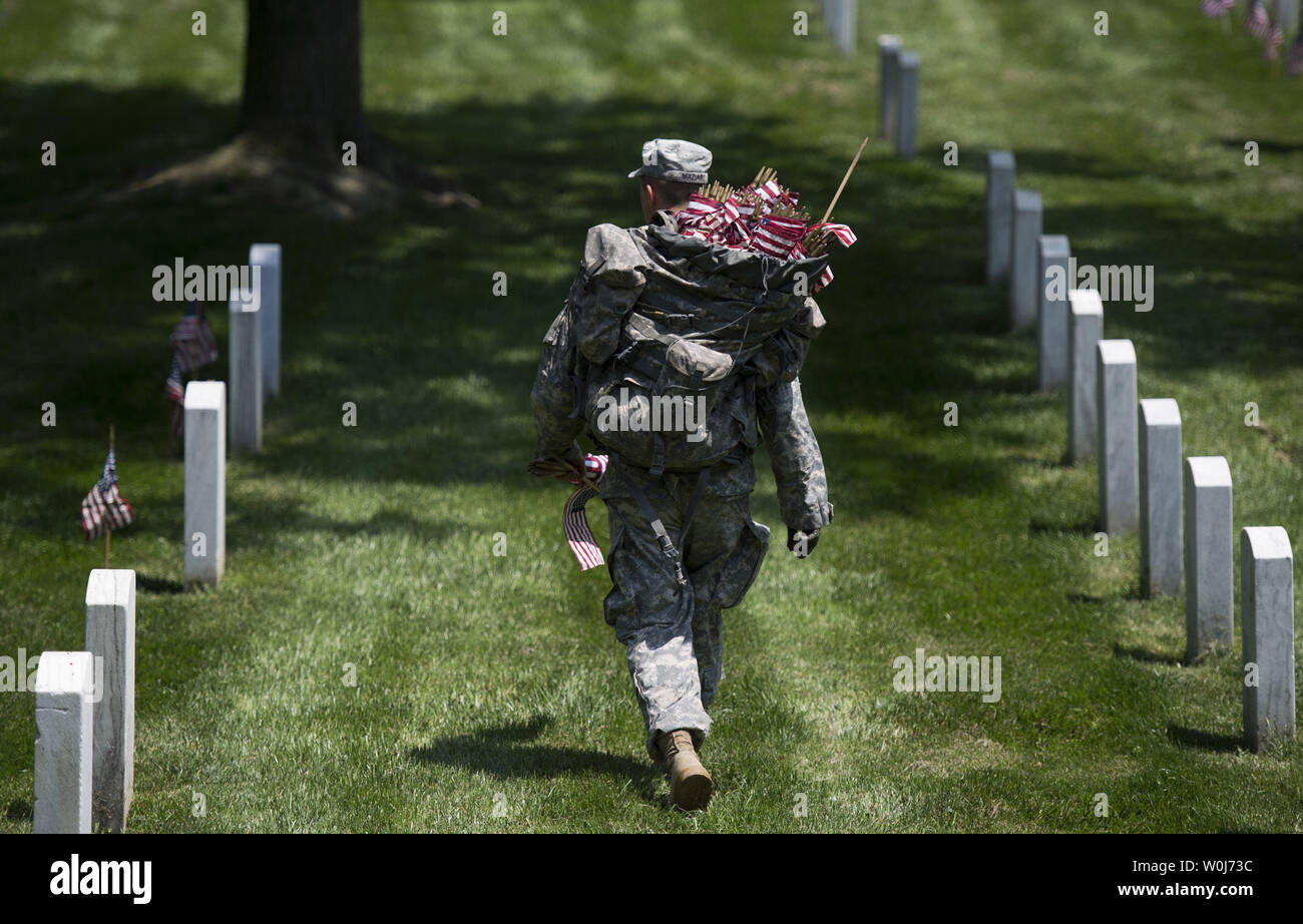 A soldier with the U.S. Army 3rd Infantry Regiment (Old Guard) walks near grave markers as he places American flag as part of the annual Flags-In event for Memorial Day at Arlington National Cemetery in Arlington, Virginia on May 26, 2016. Members of The Old Guard placed an America flag at more than 230,000 grave markers at Arlington in honor of of Nation's fallen military members. The tradition has been conducted since 1948. Photo by Kevin Dietsch/UPI Stock Photo