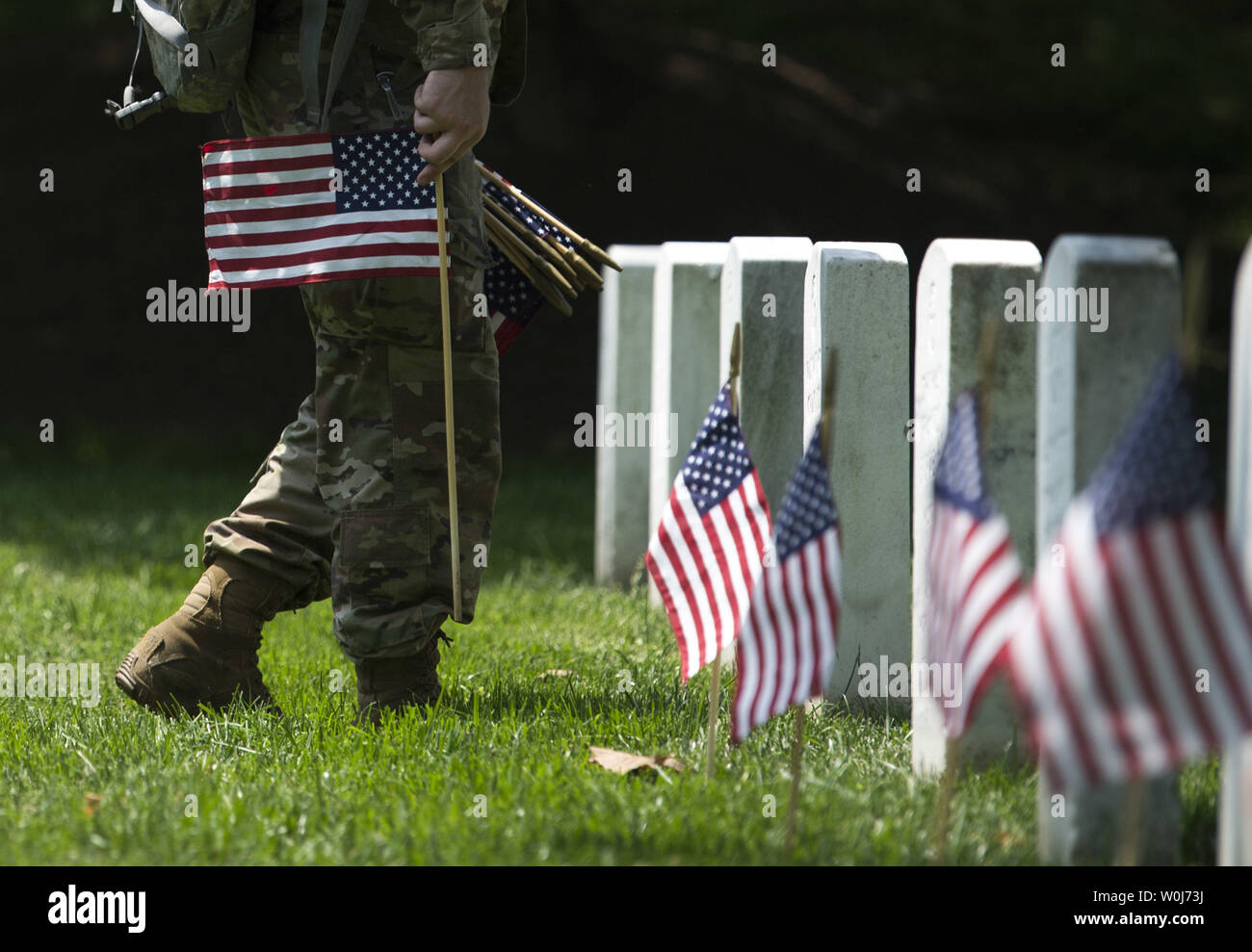 Soldiers with the U.S. Army 3rd Infantry Regiment (Old Guard) places a flag at a grave marker as part of the annual Flags-In event for Memorial Day at Arlington National Cemetery in Arlington, Virginia on May 26, 2016. Members of The Old Guard placed an America flag at more than 230,000 grave markers at Arlington in honor of of Nation's fallen military members. The tradition has been conducted since 1948. Photo by Kevin Dietsch/UPI Stock Photo