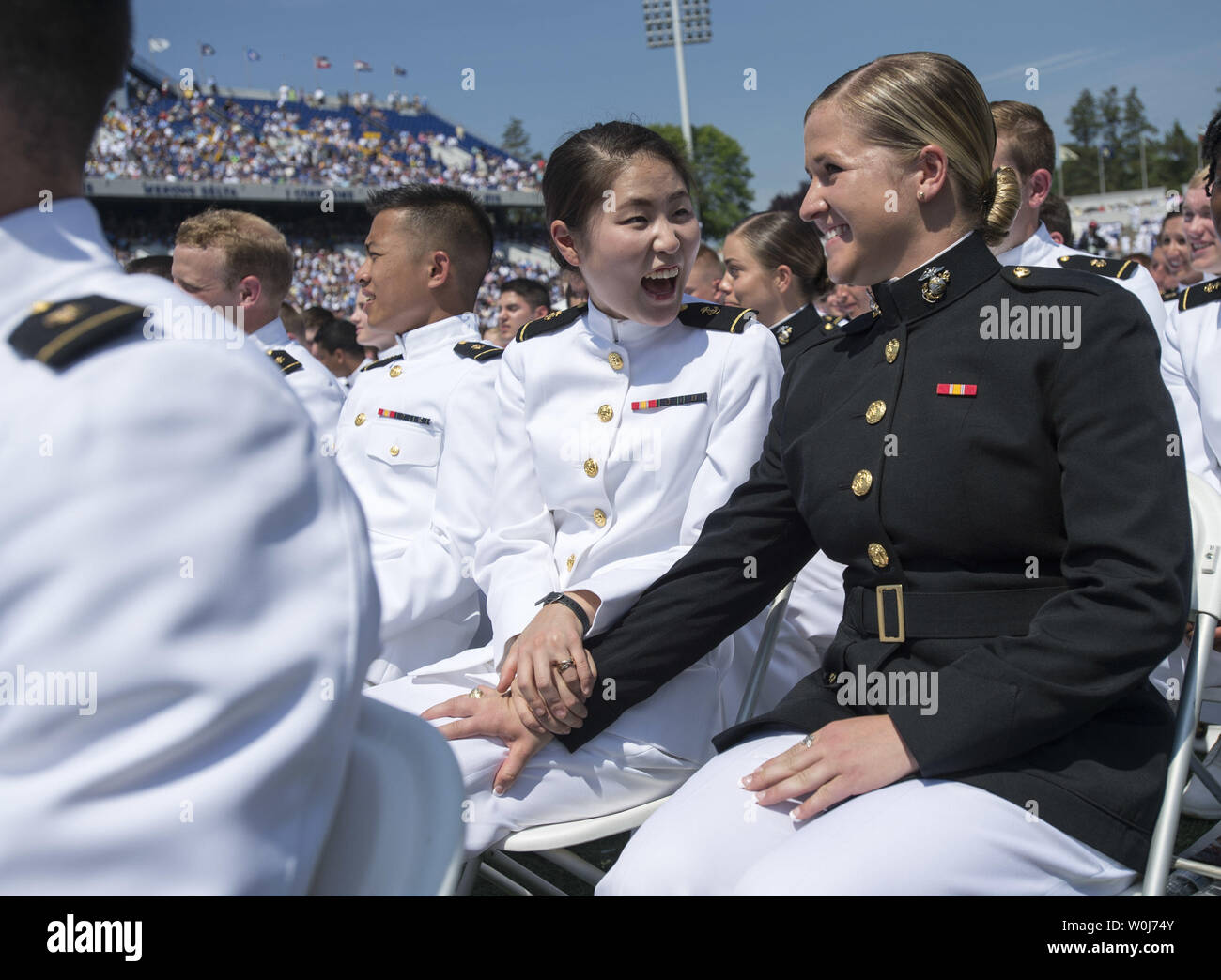 Graduating Midshipman Judith Cho (L), congratulates classmate Michaela