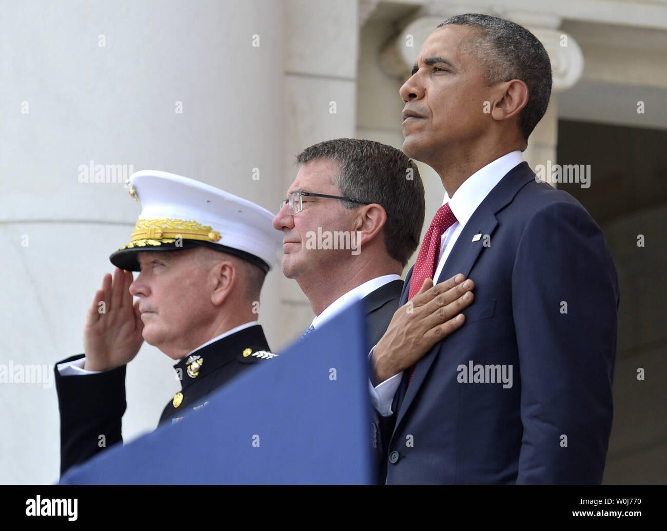 U.S.President Barack Obama (R), Chairman of the Joint Chiefs of Staff Gen. Joseph Dunford (L) and Defense Secretary Ashton Carter listen to the National Anthem at the conclusion of remarks at the Amphitheater at Arlington National Cemetery, Arlington, Virginia, on Memorial Day, May 30, 2016, near Washington, DC. Obama paid tribute to the nation's military service members who have fallen.             Photo by Mike Theiler/UPI Stock Photo