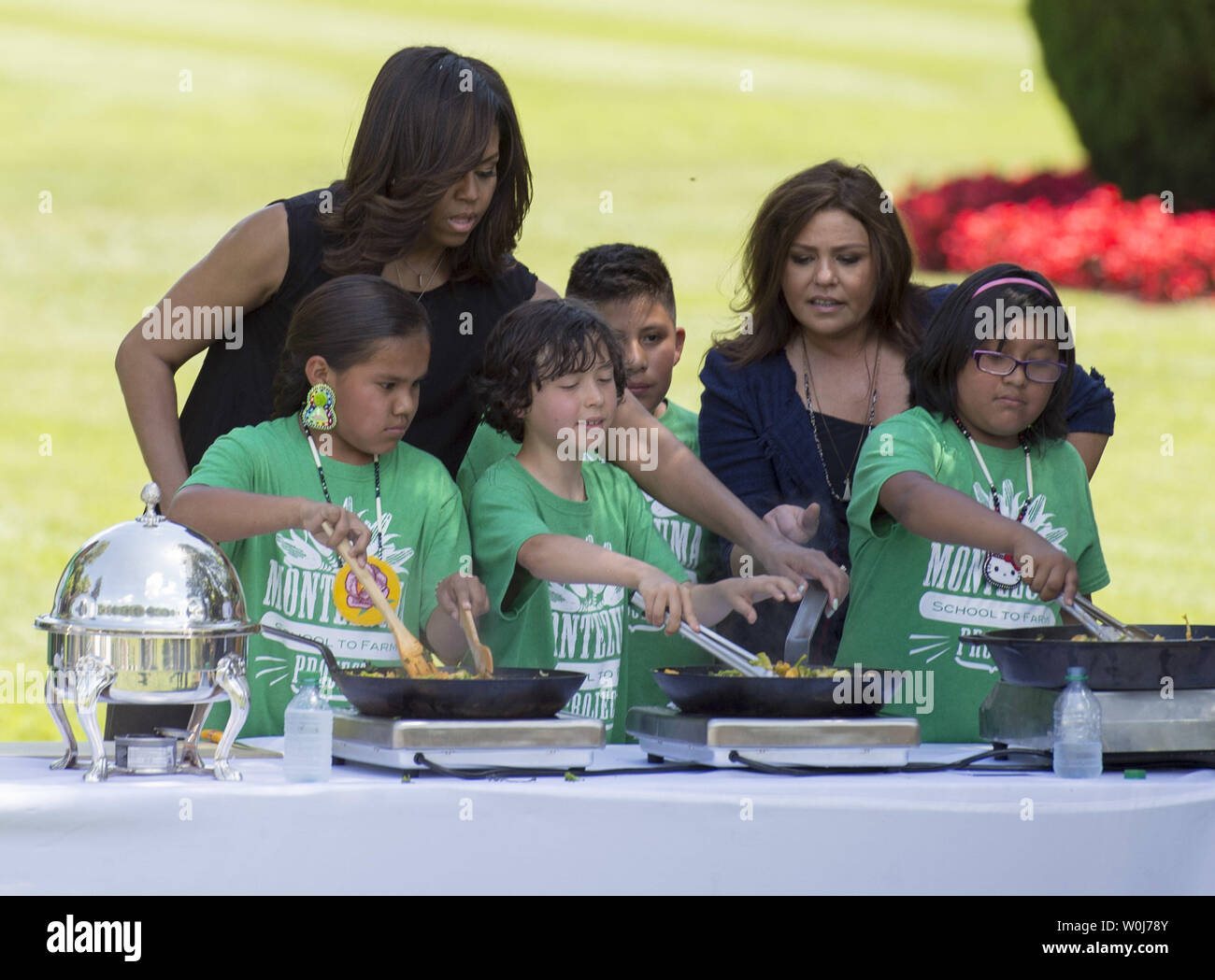 First Lady Michelle Obama makes a stir fry dish with cooking personality Rachael Ray and with school children at the White House Kitchen Garden, in Washington, D.C. in Washington, D.C. on June 6, 2016. The First Lady invited school children from around the country to help harvest the White House kitchen garden and learn about healthy eating habits. Photo by Kevin Dietsch/UPI Stock Photo