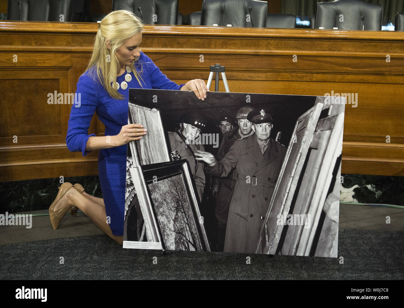 A Senate staffer adjusts World War II era photos of American soldiers recovered Nazi stolen artwork prior to a Senate Judiciary subcommittee hearing on the  HEAR Act, legislation aimed at helping Holocaust survivors and their families recover art stolen by the Nazis, on Capitol Hill in Washington, D.C. on June 7, 2016. Photo by Kevin Dietsch/UPI Stock Photo