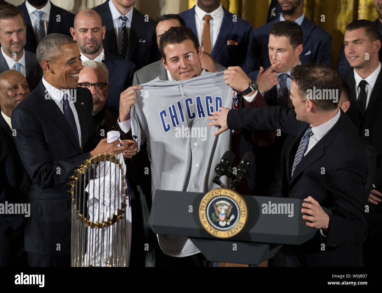 President Barack Obama smiles as Chicago Cubs first baseman Anthony Rizzo  and Chicago Cubs President of Baseball Operations Theo Epstein (R) present  him with a 'Chicago' Cubs away jersey during a ceremony