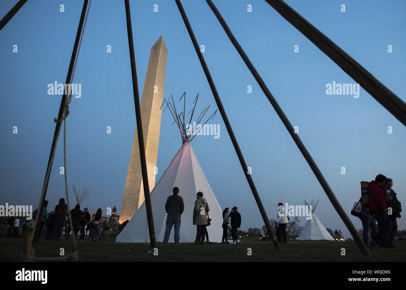 People gather near tepees set up by the Standing Rock Sioux Tribe and Native Nations Rise in protest of the Dakota Access Pipeline, near the Washington Monument on March 9, 2017 in Washington, DC. Activists and have set up teepees on the National Mall as part of a three day protest culminating in a protest march tomorrow to the White House in opposition of the Trump Administration's approval of the controversial Dakota Access pipeline through Native land. Photo by Kevin Dietsch/UPI Stock Photo