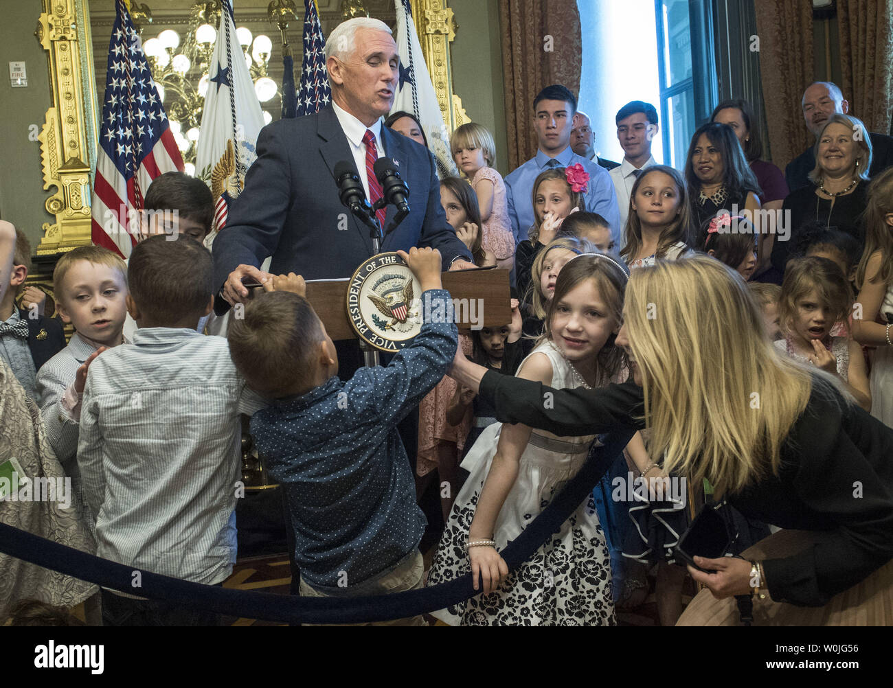 A child attempts to take the seal off of the lecture as Vice President Mike Pence delivers remarks to military families at an event recognizing National Military Appreciation Month and National Military Spouse Appreciation Day, in the Eisenhower Executive Office Building in Washington, D.C. on May 9, 2017. Photo by Kevin Dietsch/UPI Stock Photo