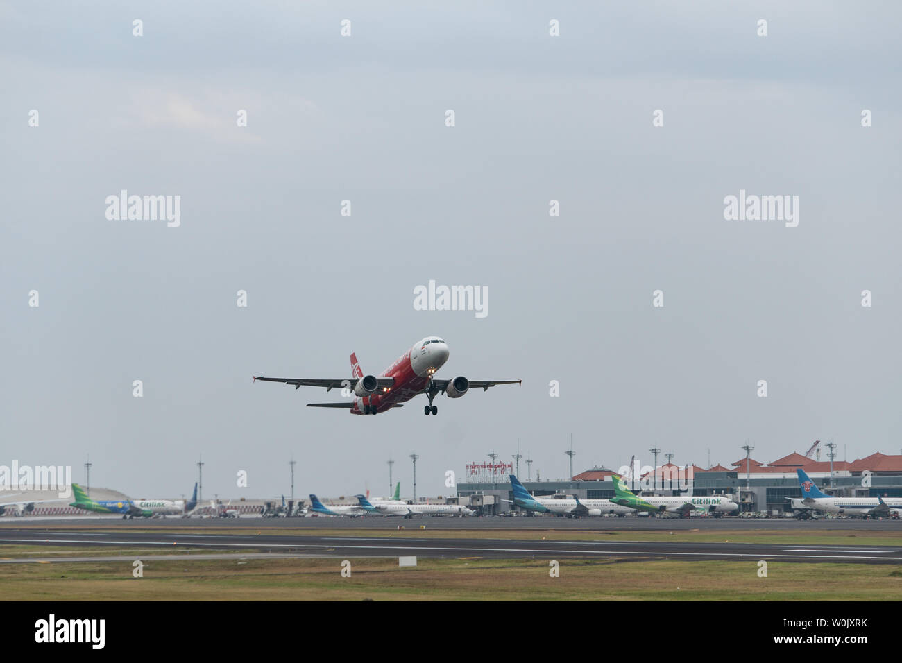 DENPASAR,BALI/INDONESIA-JUNE 08 2019: Air Asia Aeroplane (Airbus Model) is taking off from Ngurah Rai International Airport Bali runway, when the sky Stock Photo