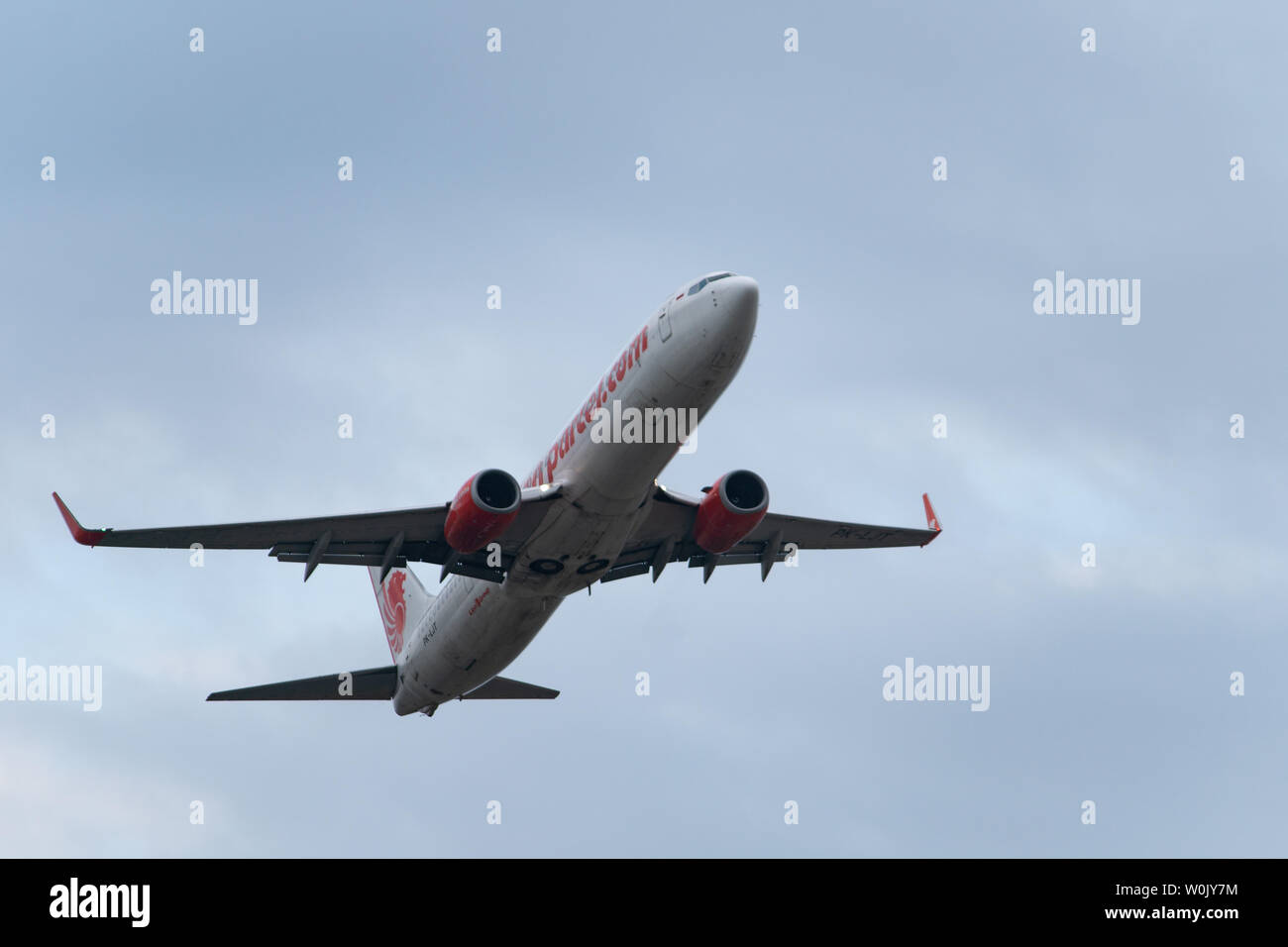 DENPASAR,BALI/INDONESIA-JUNE 08 2019: Lion air aeroplane is flying from Ngurah Rai International Airport Bali, when the sky is cloudy grey Stock Photo