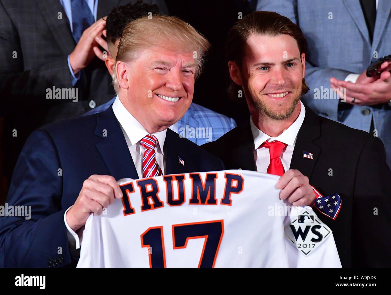 President Donald Trump (L) receives a custom jersey from Houston Astros  outfielder Josh Reddick as Trump welcomes the 2017 World Series Champion  Houston Astros to the White House on March 12, 2018