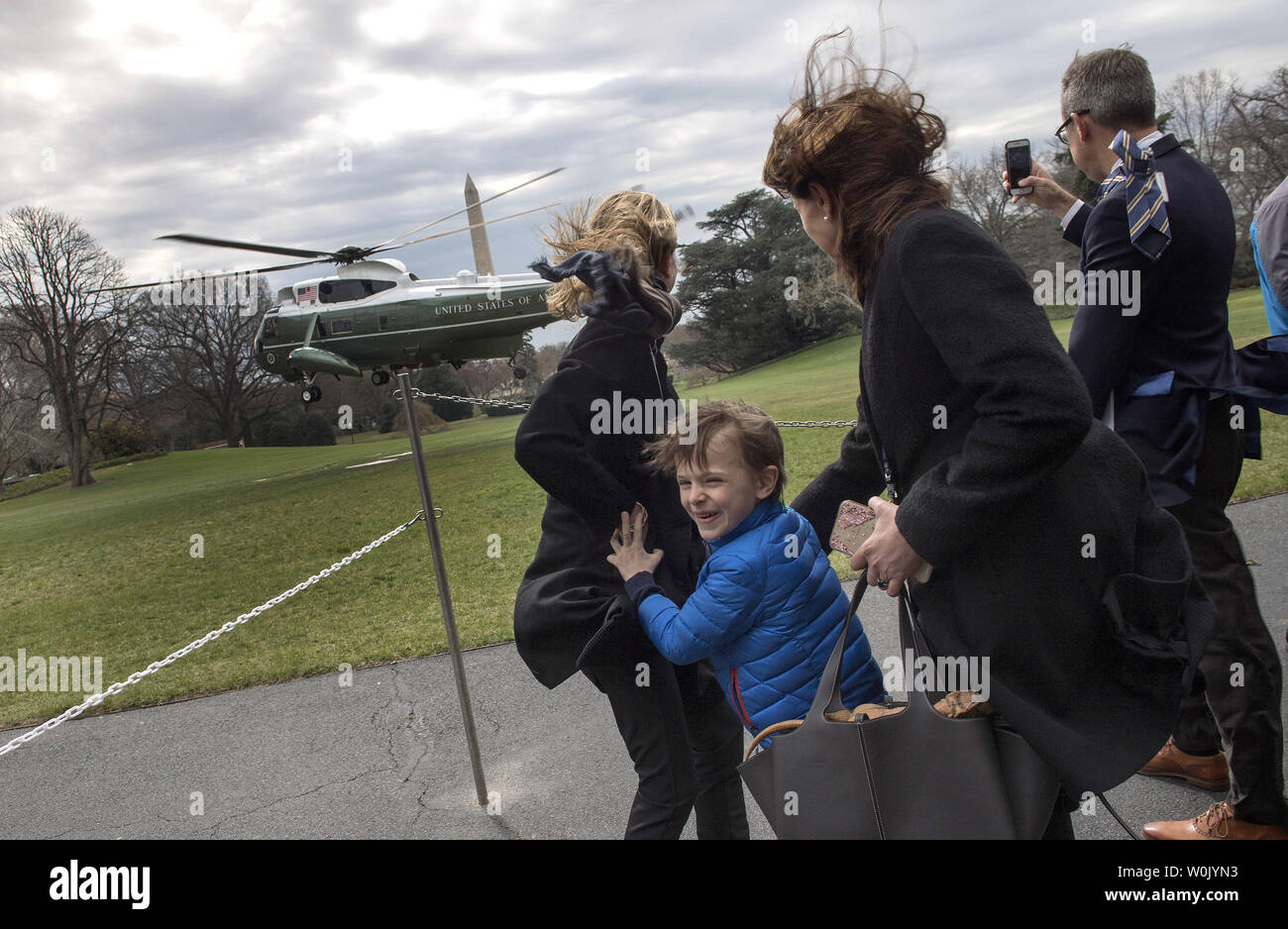 Mateo Palazzi, takes cover from rotor wash behind his mother, Mariana ...