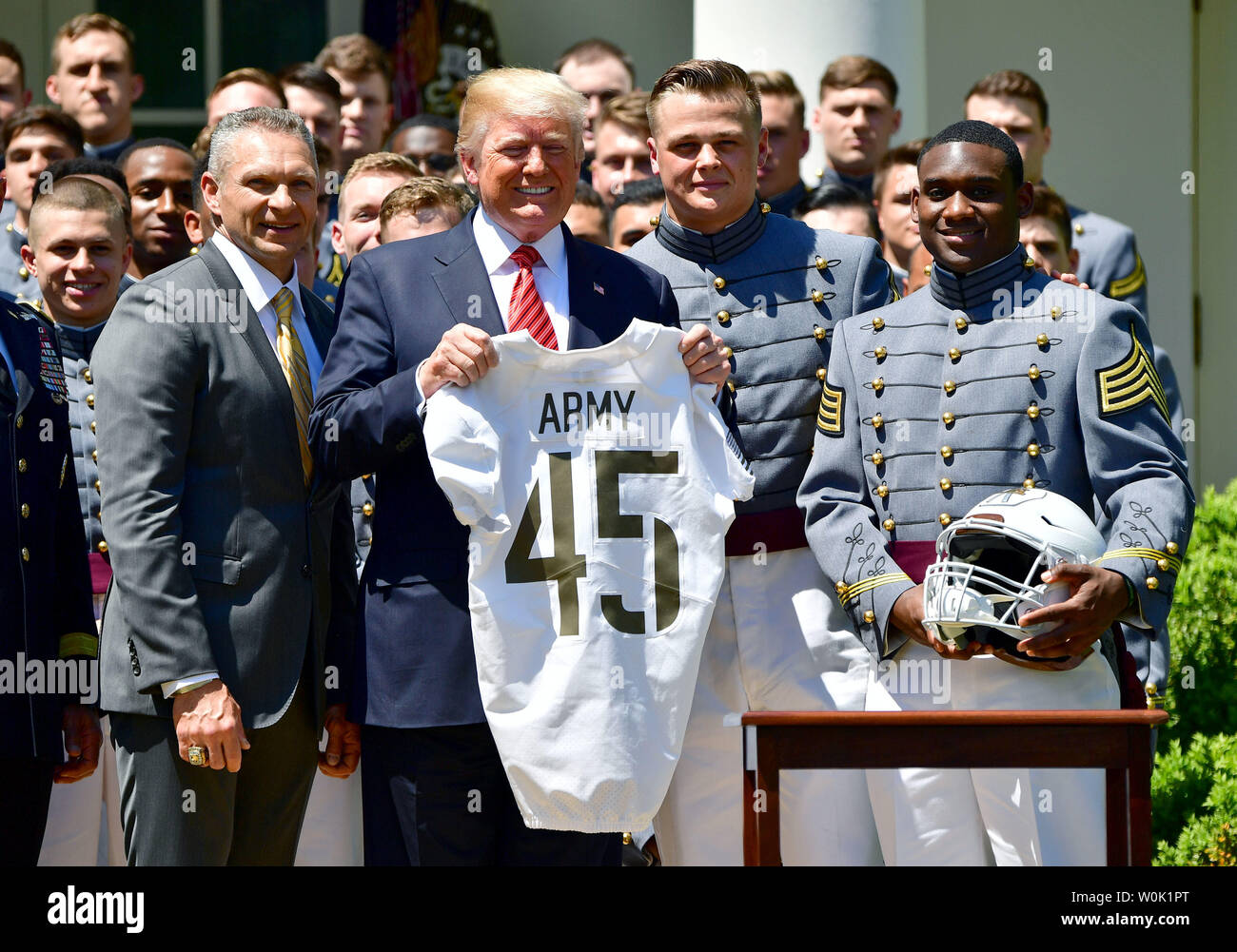 President Donald Trump receives a jersey from Army Black Nights team  captain John Voit (2nd-R), quarterback Ahmad Bradshaw (R) and head coach  Jeff Monken at a ceremony where Trump presented the Commander-in-Chief's