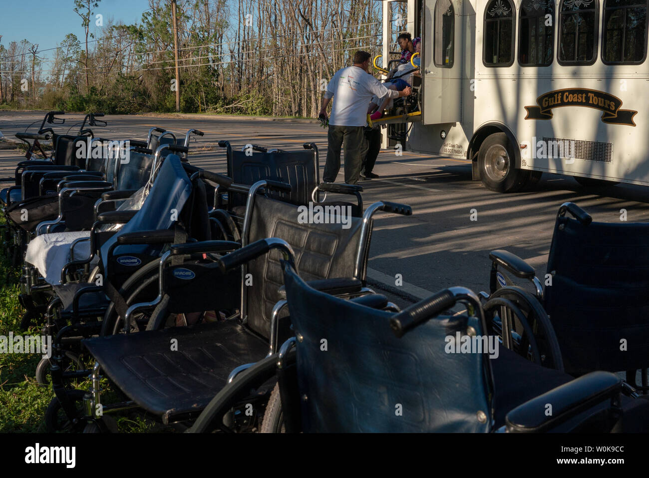 Staff help the elderly board a bus to take them from Sea Breeze Nursing