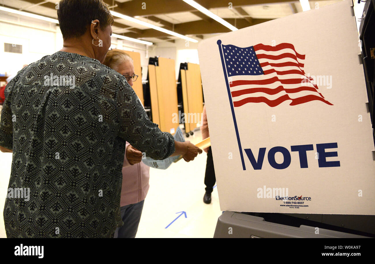 An Election Official L Helps A Voter Deposit Her Ballot At Hybla